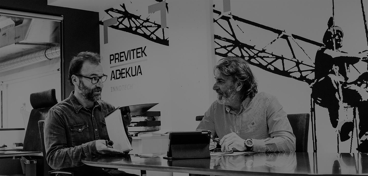 Javier Vitoria y Kepa Vitoria sentados al rededor de una mesa en las instalaciones de Previtek